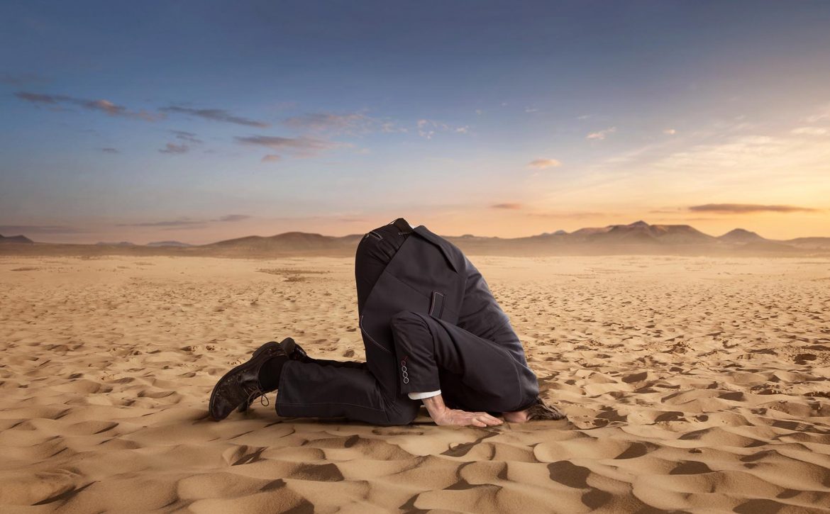 Desparate,Businessman,Hiding,Head,In,The,Sand,At,The,Desert