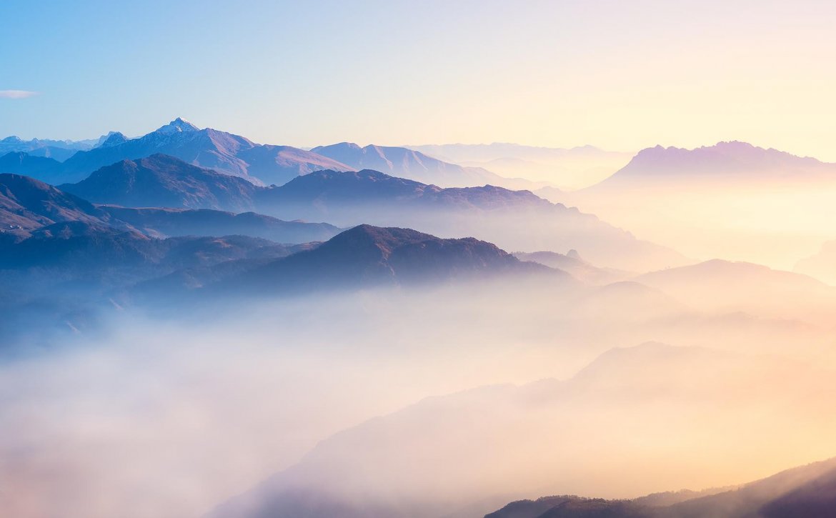 Mountain,Range,With,Visible,Silhouettes,Through,The,Morning,Colorful,Fog.