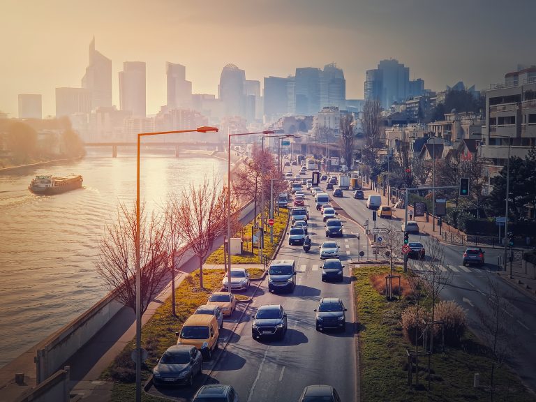 Circulation sur les quais d’Asnières-sur-Seine au coucher du soleil, avec vue sur La Défense et la Seine, où opère Puck L’Agence, agence de communication et marketing B2B.